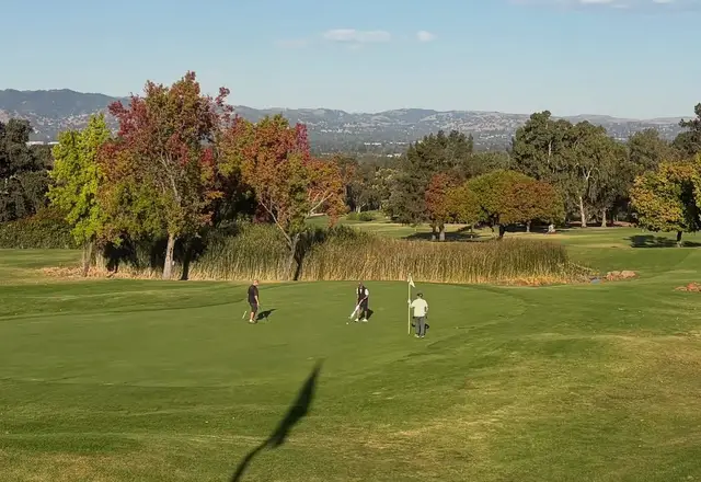 Golfers on a green among autumn trees at Boundary Oak