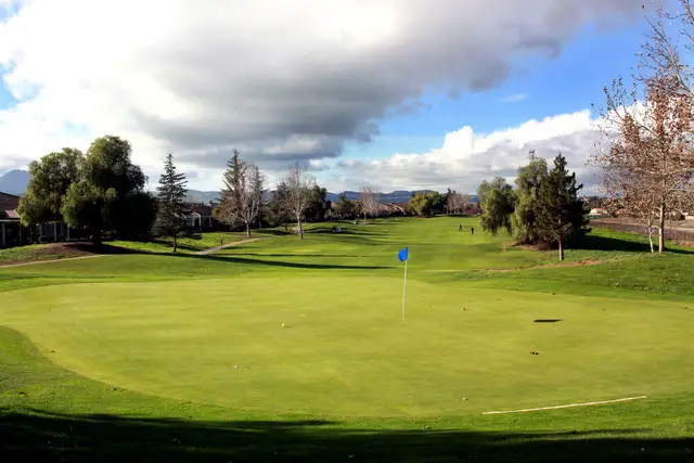 Wide green under a cloudy sky at Brentwood Golf Club
