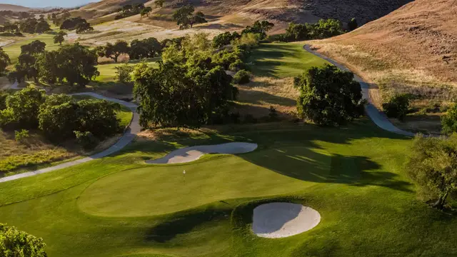 Green framed by oaks and golden hills