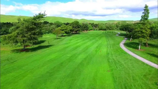 Wide fairway with green hills beyond