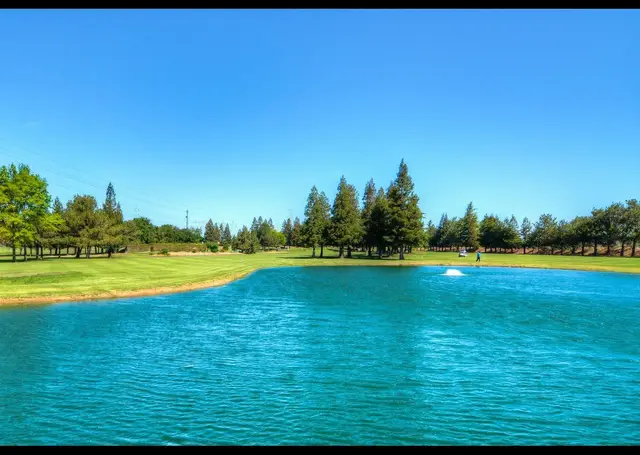 Lake in front of a green at Emerald Lakes