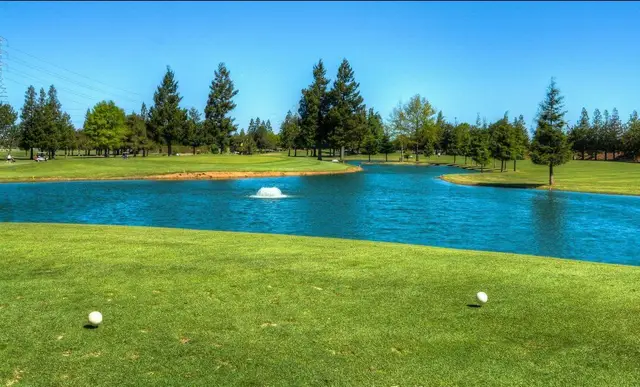 Pond with fountain beside a fairway