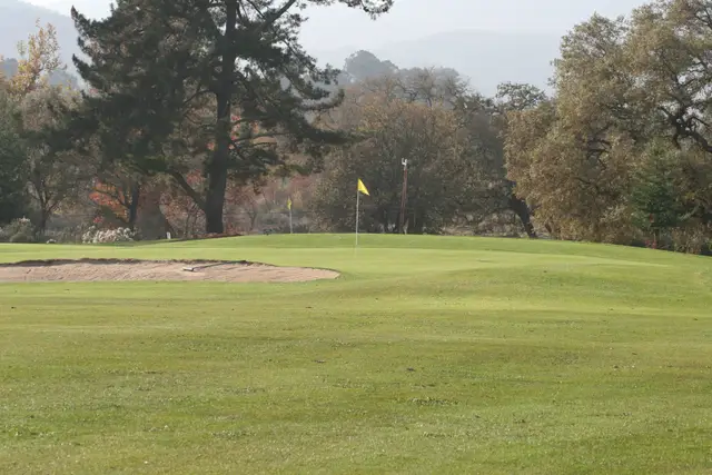 Bunkered green with autumn trees