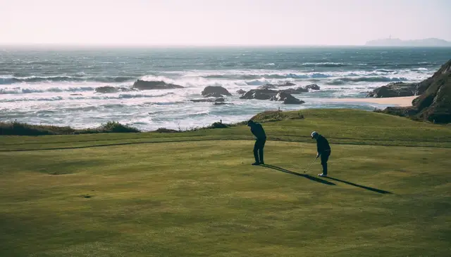 Golfers on a green above the surf at Half Moon Bay