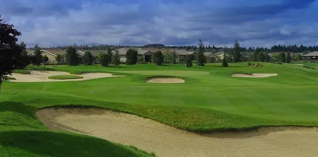 Bunkered green under a moody sky