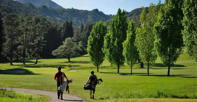 Golfers walking with Mount Tamalpais behind