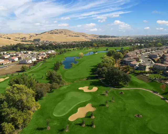Aerial view of bunkered greens and golden hills
