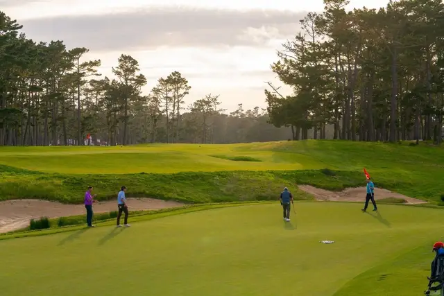 Golfers on a green at golden hour