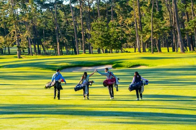 Golfers walking a fairway in the forest