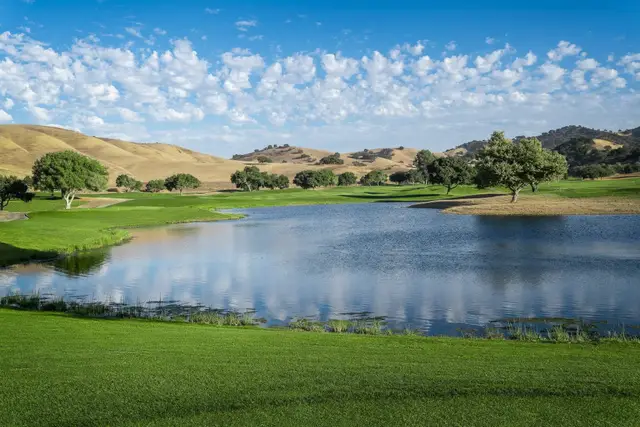 Lake reflecting the golden hills at San Juan Oaks