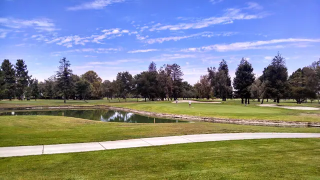 Pond in front of a green under a big sky