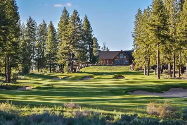 Clubhouse beyond a bunkered green